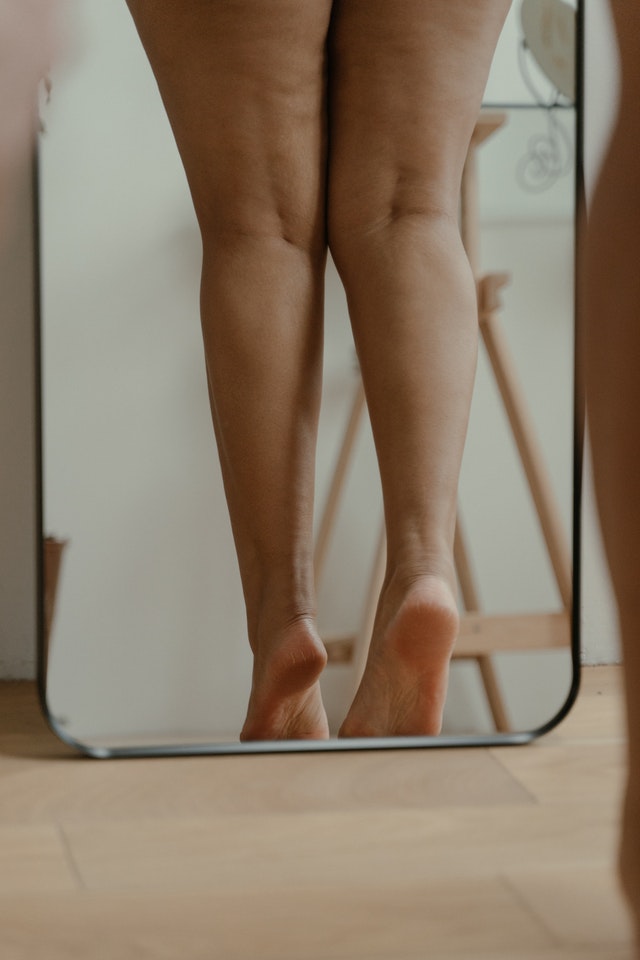 woman's legs standing in mirror